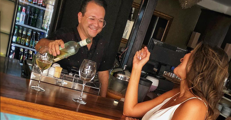 Picture of the bar area of the Costa Rica Medical Center Inn, San Jose, Costa Rica.  The picture shows a drink being poured for a female guest sitting on a bar stool.