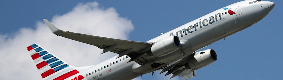 Picture of an American Airlines airplane bringing frontline heroes to Costa Rica for cosmetic dental work with Frontline Dental CR.  The airplane has American’s new colors and the sky is blue with a single white cloud in the background.